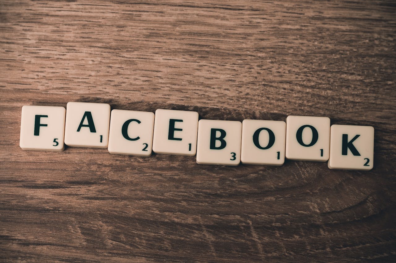 Scrabble tiles spelling Facebook on a wood background, symbolizing social media.